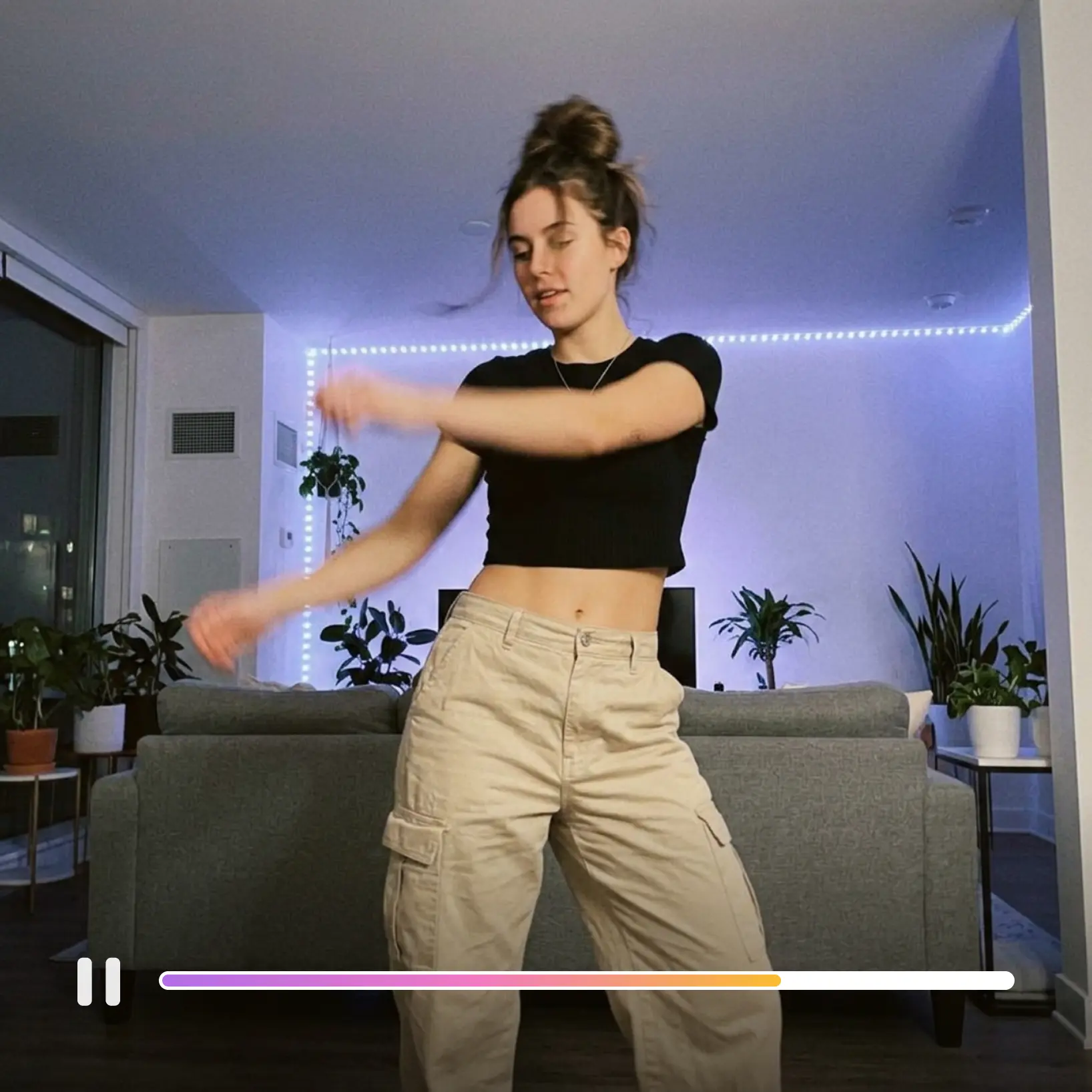 Lift Text to Video AI rendering a dance clip from a written prompt with playback controls visible Young woman dancing in a city apartment with LED strip lights, generated by Lift text to video AI