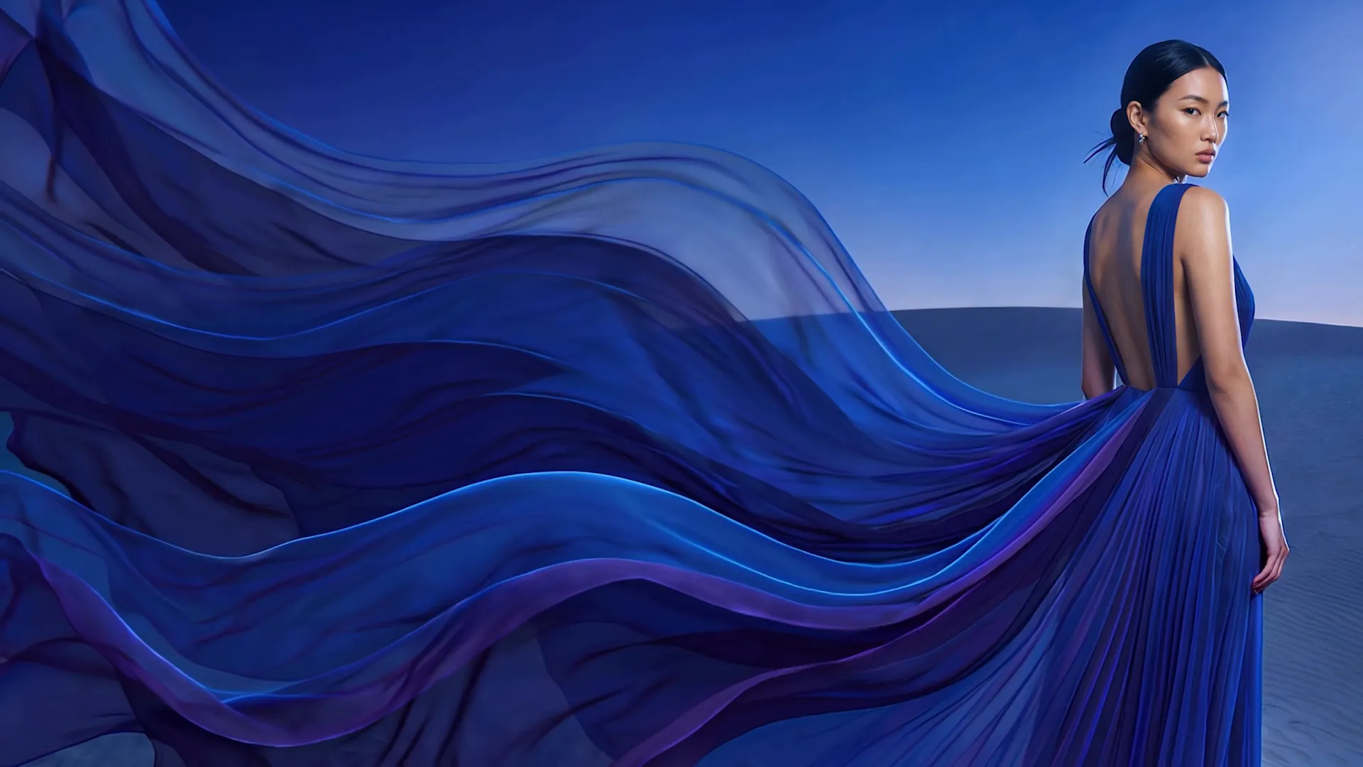 Woman in a flowing blue dress in the desert at dusk