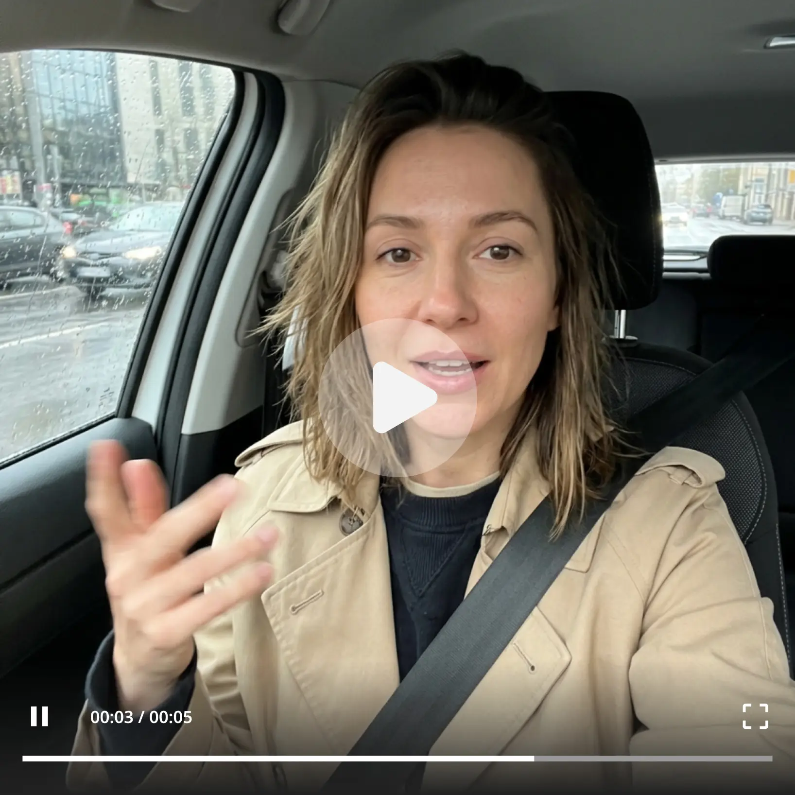 Lift Text to Video AI playing a polished five-second vlog clip generated from a written prompt Woman in trench coat speaking in a rainy-day car clip created with Lift text to video AI